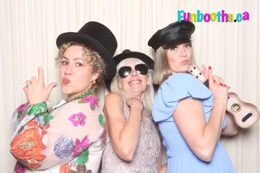 Three friends in hats and sunglasses posing in the Funbooths photo booth