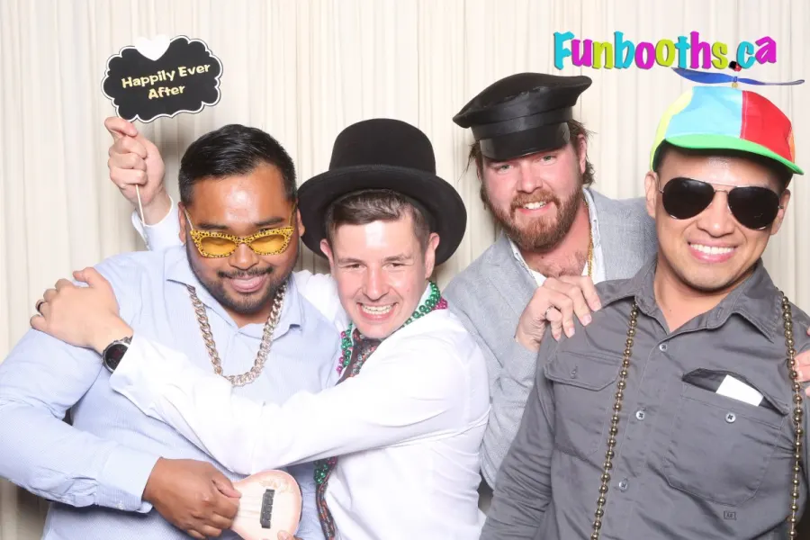 Groomsmen holding a "Happily Ever After" sign at a wedding photo booth